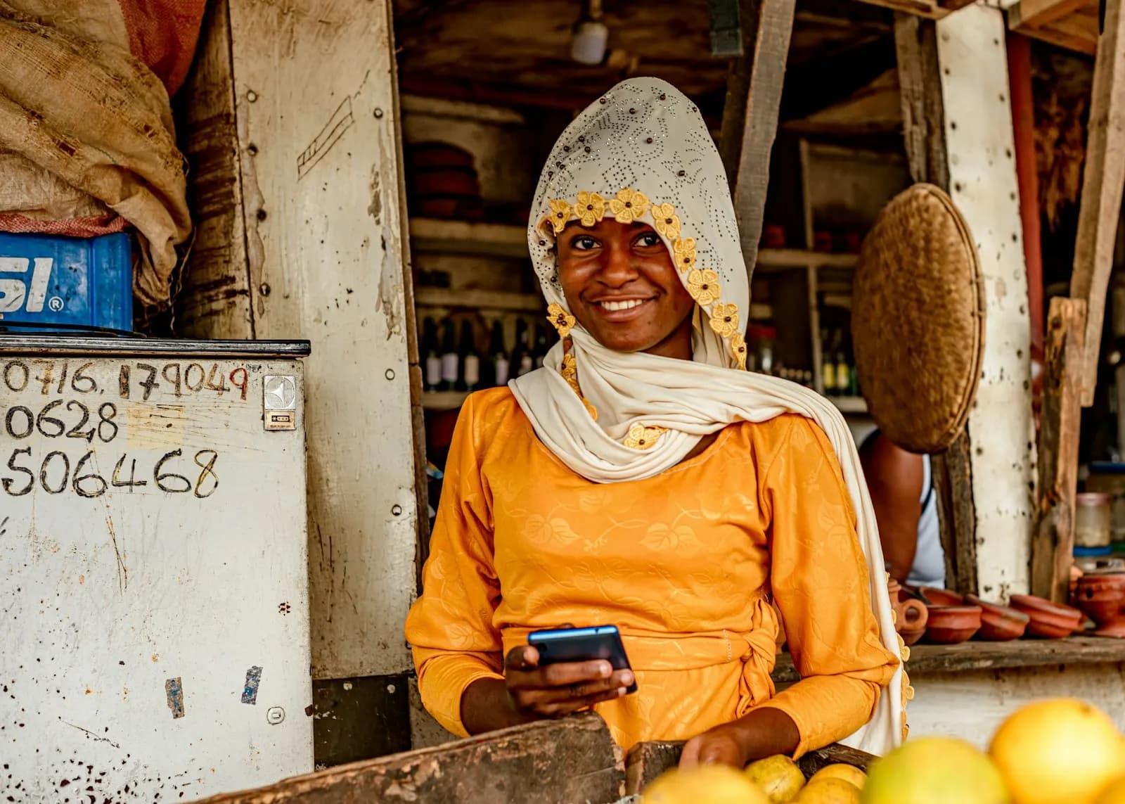 Commerçante souriante utilisant son téléphone